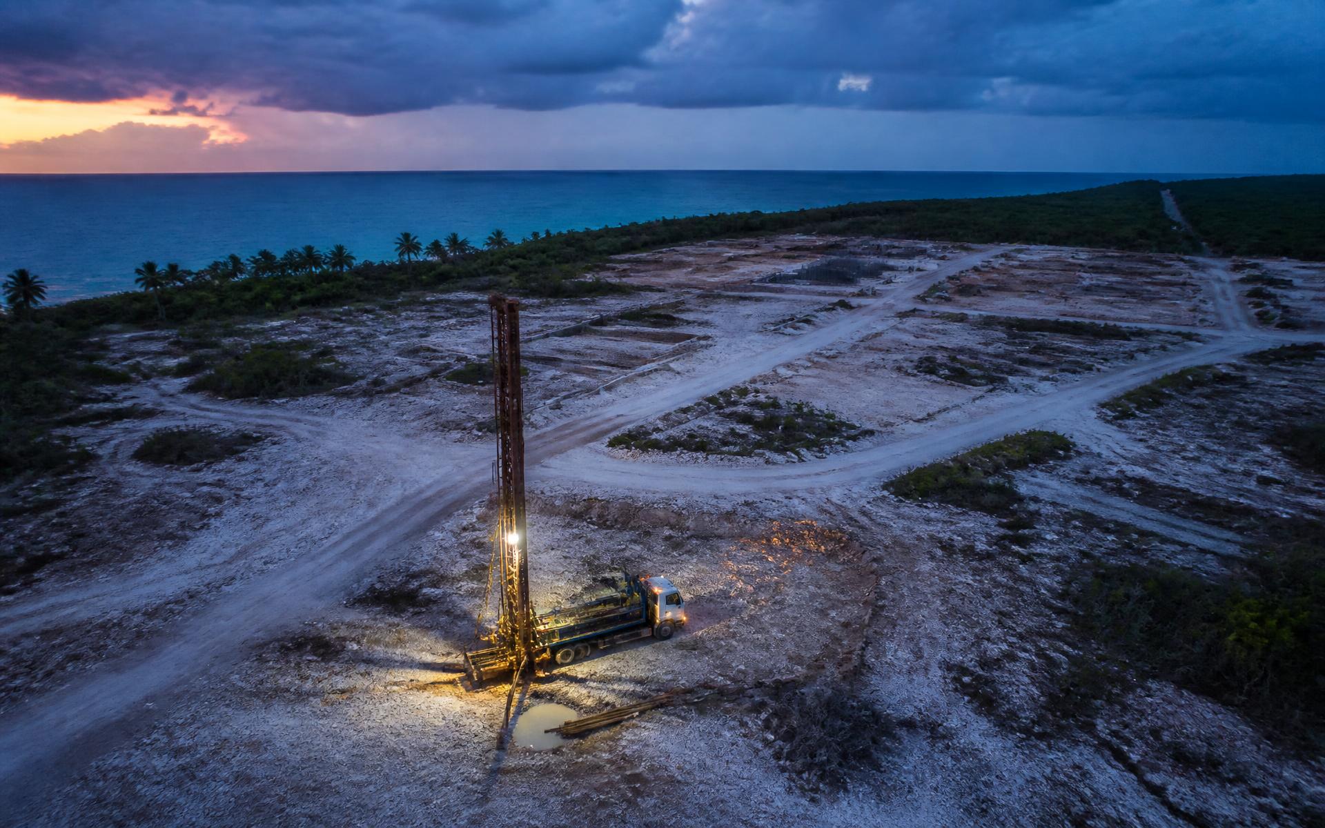 Equipo de perforación operando al atardecer en un predio de la costa de Quintana Roo
